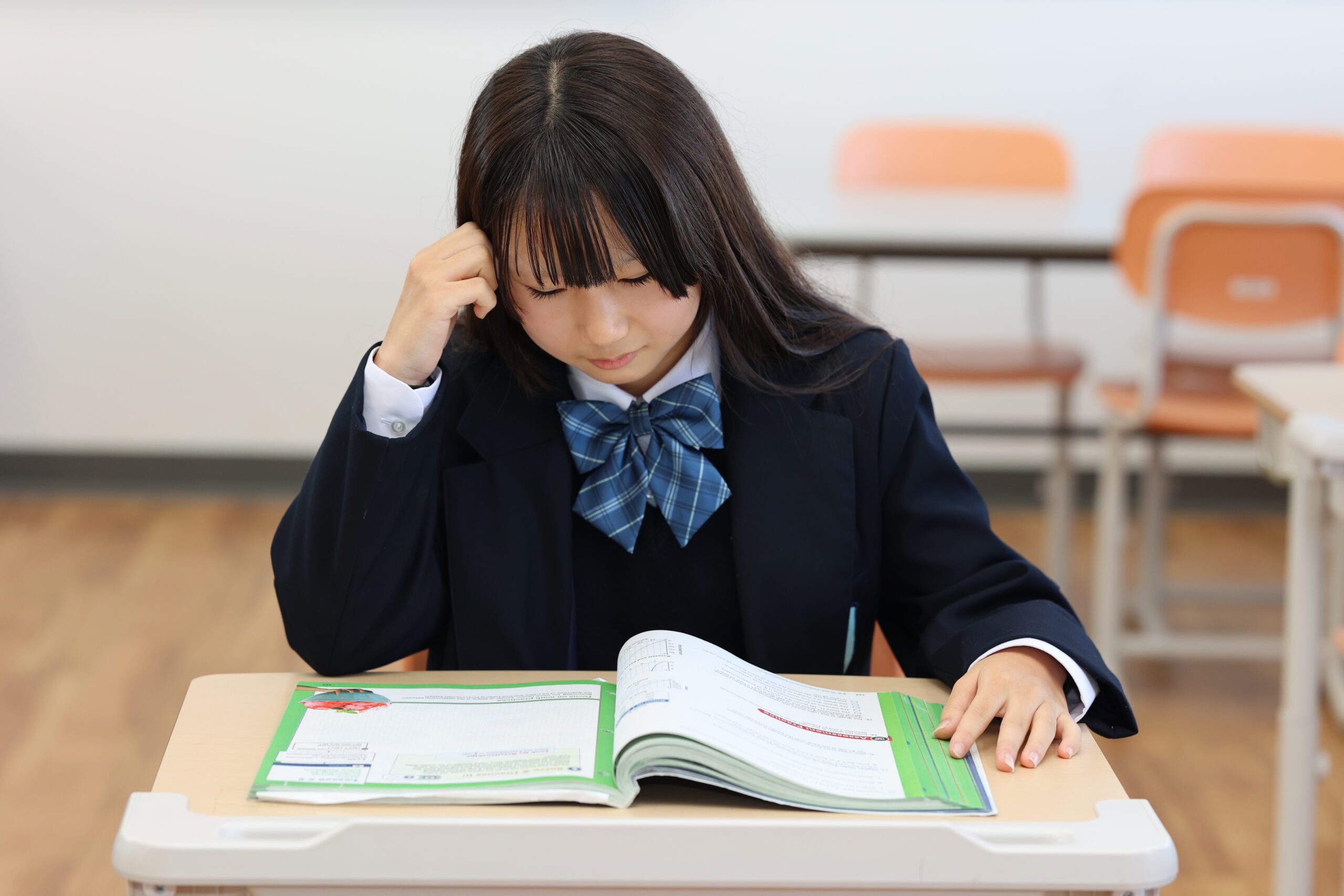 World-Class academics and education being taught at One World International School. A secondary school student read a textbook and thinks deeply (thinking)